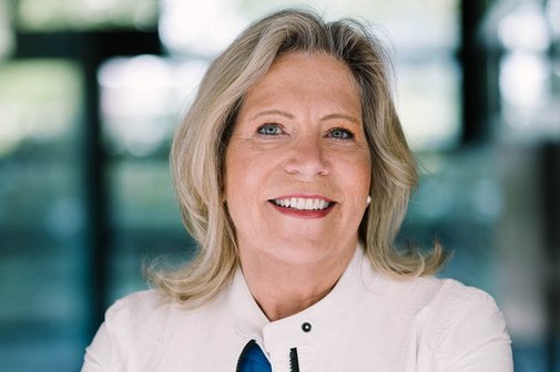Das Portraitfoto zeigt Susanne Pfab, sie hat die Arme verschränkt und lächelt in die Kamera.